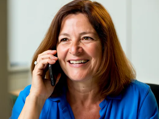 Une conseillère souriante, au téléphone.